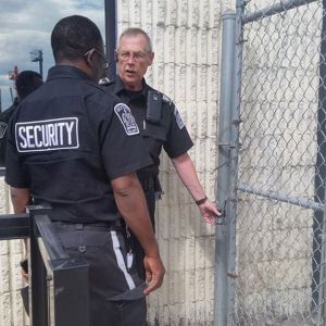 two security guards securing a gate at a commercial building