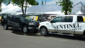 two sentinel protection services trucks parked at an event
