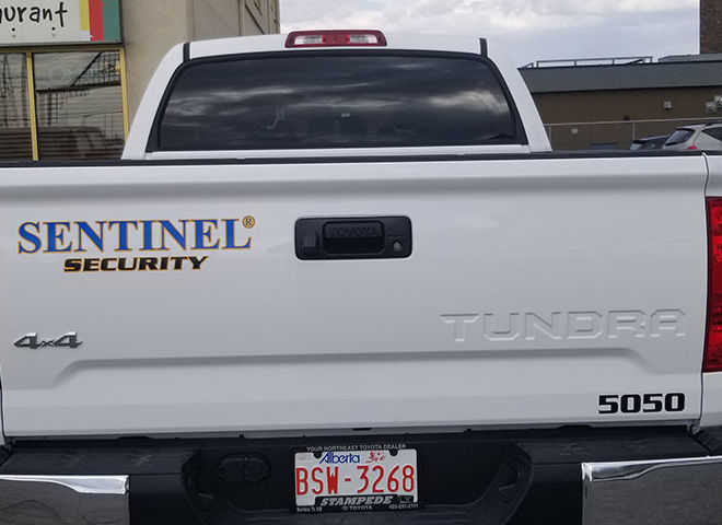 rear view of white 4 door pick up truck with sentinel security logo on tailgate